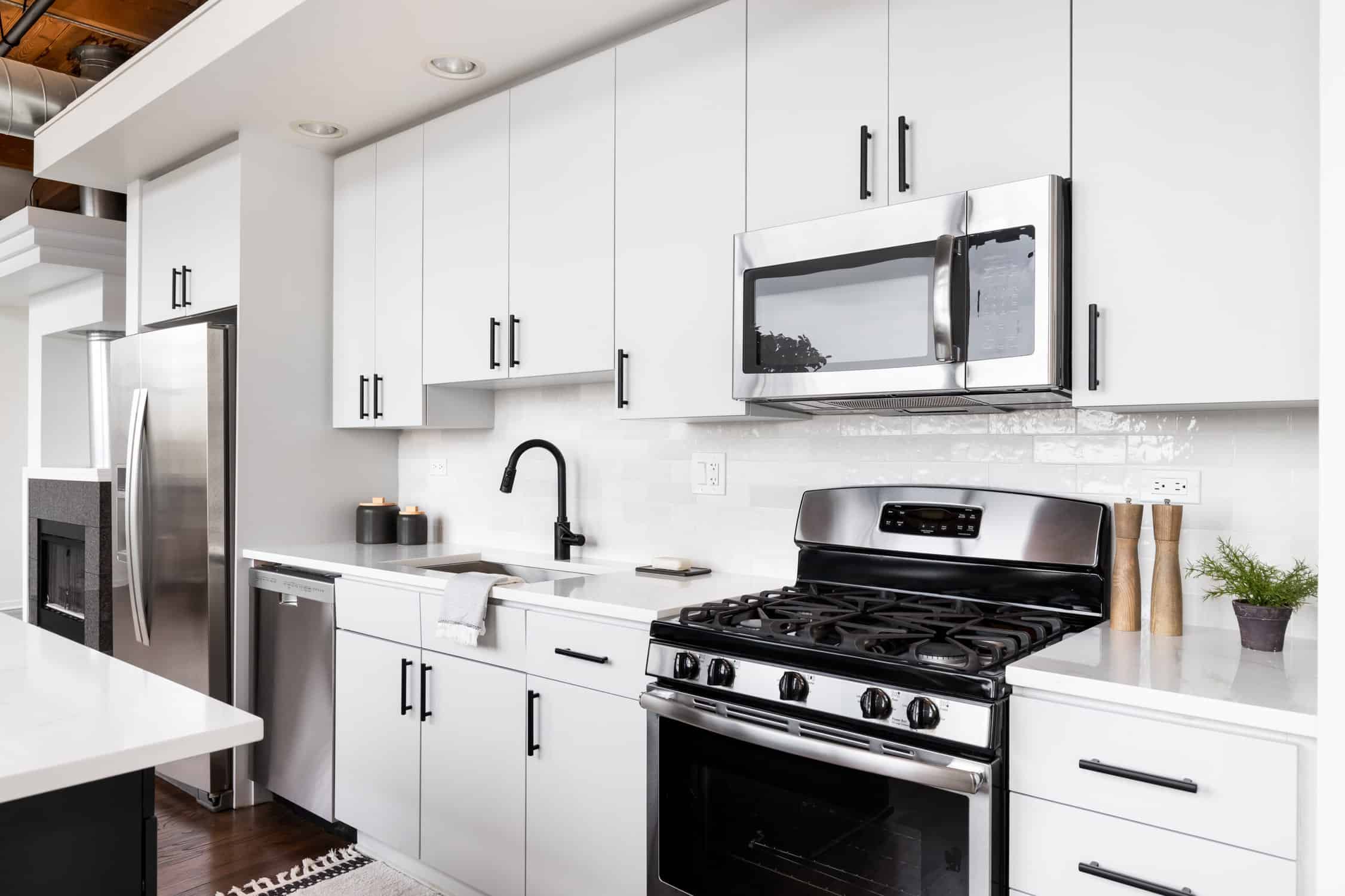 A white kitchen with stainless steel appliances.